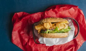 Burger con il pesce con l’impanatura Fishburger con crauti